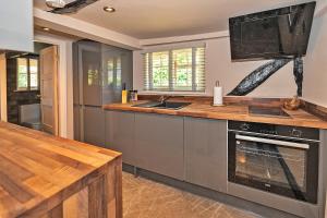 a kitchen with a stove and a counter top at Finest Retreats - Pemberley Cottage 