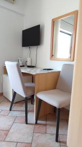 a desk with two chairs and a computer monitor at Guesthouse ROCK & ROLL in Rovinj