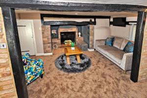 un soggiorno con divano e tavolo di Finest Retreats - Pemberley Cottage 