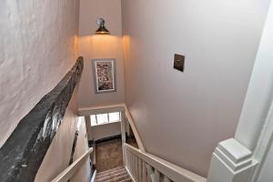 a hallway with a stairway with a stair railing at Finest Retreats - Pemberley Cottage 