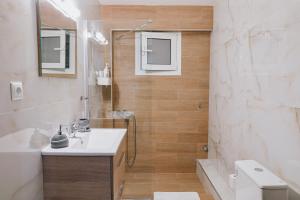 a bathroom with a sink and a shower and a toilet at C Apartments in Melissátika