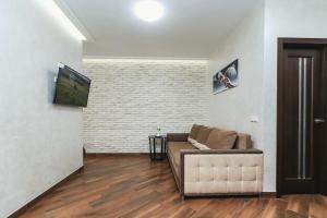 sala de estar con sofá y TV en Cozy apartment on Belvedere, en Ivano-Frankivsk