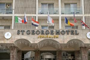 una fachada de un hotel con banderas de diferentes países en St. George Hotel, en Jerusalén