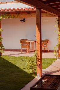d'une terrasse avec une table et des chaises sous une pergola. dans l'établissement Casa do Lado, à Vila Nova de Milfontes