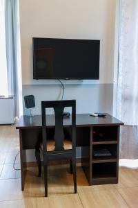 a desk with a chair and a television on a wall at Motel Kobilj in Banja Luka