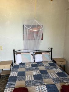 a bedroom with a bed with a checkered quilt at Hamre Apartments (Nicholas) in Agios Georgios Pagon