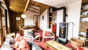 a living room with a wood burning stove and a table at Haus Caroline, Riederalp Mitte Studio in Riederalp