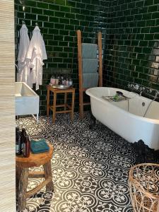 La salle de bains est pourvue d'une baignoire et d'un mur vert. dans l'établissement Suites Elswoutshoek, à Overveen