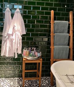 un baño con una pared de azulejos verdes y una mesa con cosméticos en Suites Elswoutshoek, en Overveen