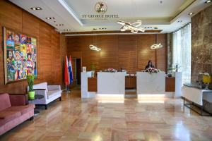 a lobby of a hotel with a woman sitting at a desk at St. George Hotel in Jerusalem