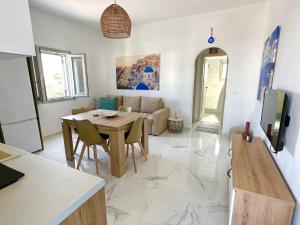 a kitchen and living room with a table and a couch at Santana Apartments in Perivolos