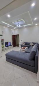 a living room with a couch and a tv at Agreable appartement dans une résidence calme sécurisée in El Harhoura