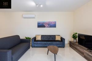 ein Wohnzimmer mit einem Sofa und einem TV in der Unterkunft Serene 2BR Apartment with Picturesque Views by 360 Estates in Marsaxlokk