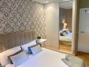 a bedroom with a bed and a large mirror at Nuevo Terraza y parking, 2 hab, 2 baños, 6-7 p, Abierto alquiler Mayo y Jun min 3 noches in Llanes