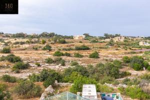 Blick auf ein Feld mit Häusern und Bäumen in der Unterkunft Serene 2BR Apartment with Picturesque Views by 360 Estates in Marsaxlokk
