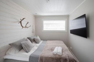 Schlafzimmer mit einem Bett und einem Flachbild-TV in der Unterkunft Villa Aito, Iso-Syöte in Syöte