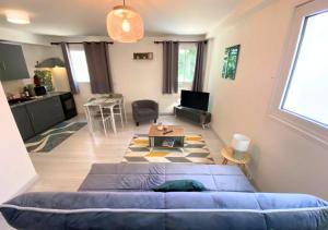 a living room with a blue couch and a table at Chez Aïda-Centre Ville Poitiers-La Conciergerie. in Poitiers