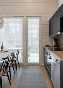 a kitchen with a table and some chairs and a counter at Villa Aito, Iso-Syöte in Syöte