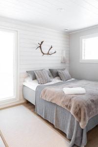 1 dormitorio con 1 cama con una rama en la pared en Villa Aito, Iso-Syöte, en Syöte