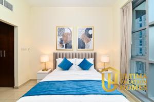 a bedroom with a large bed with blue pillows at Stylish 1BR-Next to Dubai Mall in Standpoint B in Dubai +7 photos