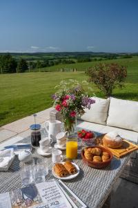 a table with a breakfast of bread and orange juice at Kipney Farmhouse - luxury hunting lodge in Perth
