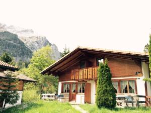 a wooden house with a balcony in the mountains at Alpen Chalet in Kandersteg