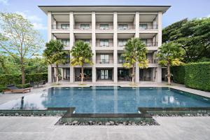 une piscine en face d'un bâtiment dans l'établissement The Sala Pattaya - SHA Certified, à Jomtien Beach
