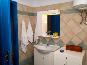 ein Bad mit einem Waschbecken und einem Spiegel in der Unterkunft Meli Apartments near sea side in Kýthira