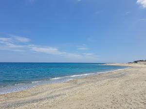 una spiaggia sabbiosa con l'oceano sullo sfondo di Casa Solaris a SantʼAndrea Apostolo dello Ionio
