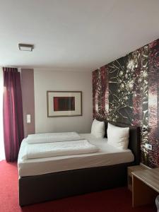 Hotel Aggertal في غومرسباخ: غرفة نوم بسرير كبير عليها لوحة على الحائط