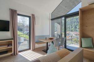 a living room with a couch and a large window at Villa Rames in Ortisei