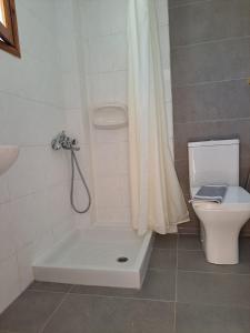 a bathroom with a bath tub next to a toilet at Studios Stavris in Frangokastello