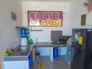 a small kitchen with a desk and a refrigerator at Truth be Found Ministry Resort in Jagna