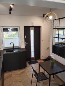 a kitchen and dining room with a table and a sink at Apartament Nowy Władek 1 in Władysławowo