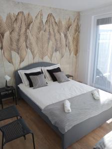 a bedroom with a large bed with a wall with feathers at Apartament Nowy Władek 1 in Władysławowo