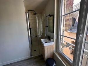 a small bathroom with a sink and a window at Appartement de charme entier, ambiance maison avec vue in Trouville-sur-Mer +8 photos