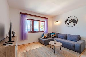 ein Wohnzimmer mit einem Sofa und einem TV in der Unterkunft Beachfront Villa Tempera with Seaview in Blato