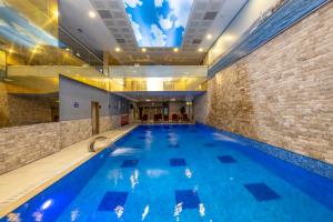 a large indoor swimming pool with blue water at Harmony Hotel Merter & SPA in Istanbul