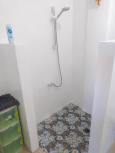 a bathroom with a shower with a tile floor at Truth be Found Ministry Resort in Jagna