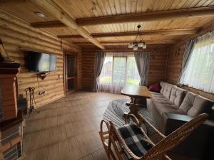 ein Wohnzimmer mit einem Sofa und einem TV in der Unterkunft Боброва-Хата in Switjas