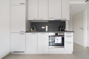 uma cozinha branca com armários brancos e um fogão em Ruhig, hell und neu mit Garage em Viena