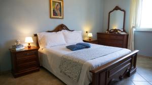 een slaapkamer met een bed met 2 nachtkastjes en een spiegel bij SUNNY HOUSE in Diano dʼAlba