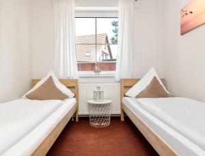 2 camas en una habitación con ventana en Haus Sonnenschein Sonnenwinkel, en Poel