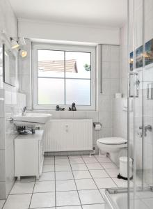 a bathroom with a sink and a toilet and a window at Haus Sonnenschein Sonnenwinkel in Insel Poel