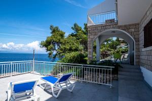 a balcony with two chairs and the ocean at Beachfront Villa Tempera with Seaview in Blato