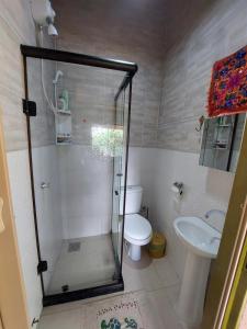 a bathroom with a shower and a toilet and a sink at Chalé tribal in Alto Paraíso de Goiás