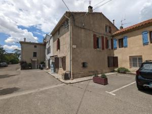 um parque de estacionamento vazio em frente a um edifício em Grande maison de village em Villedaigne