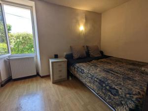 a small bedroom with a bed and a window at Grande maison de village in Villedaigne