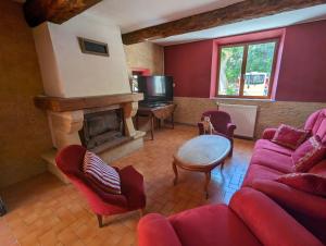 a living room with a red couch and a fireplace at Grande maison de village in Villedaigne