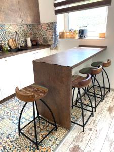 a kitchen with a large counter with stools around it at Residence Park lovely apartman with private parking in Kysucké Nové Mesto